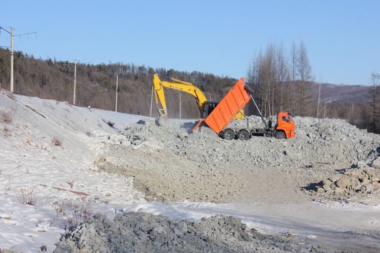 Экскаватор и самосвал на отсыпке земляного полотна